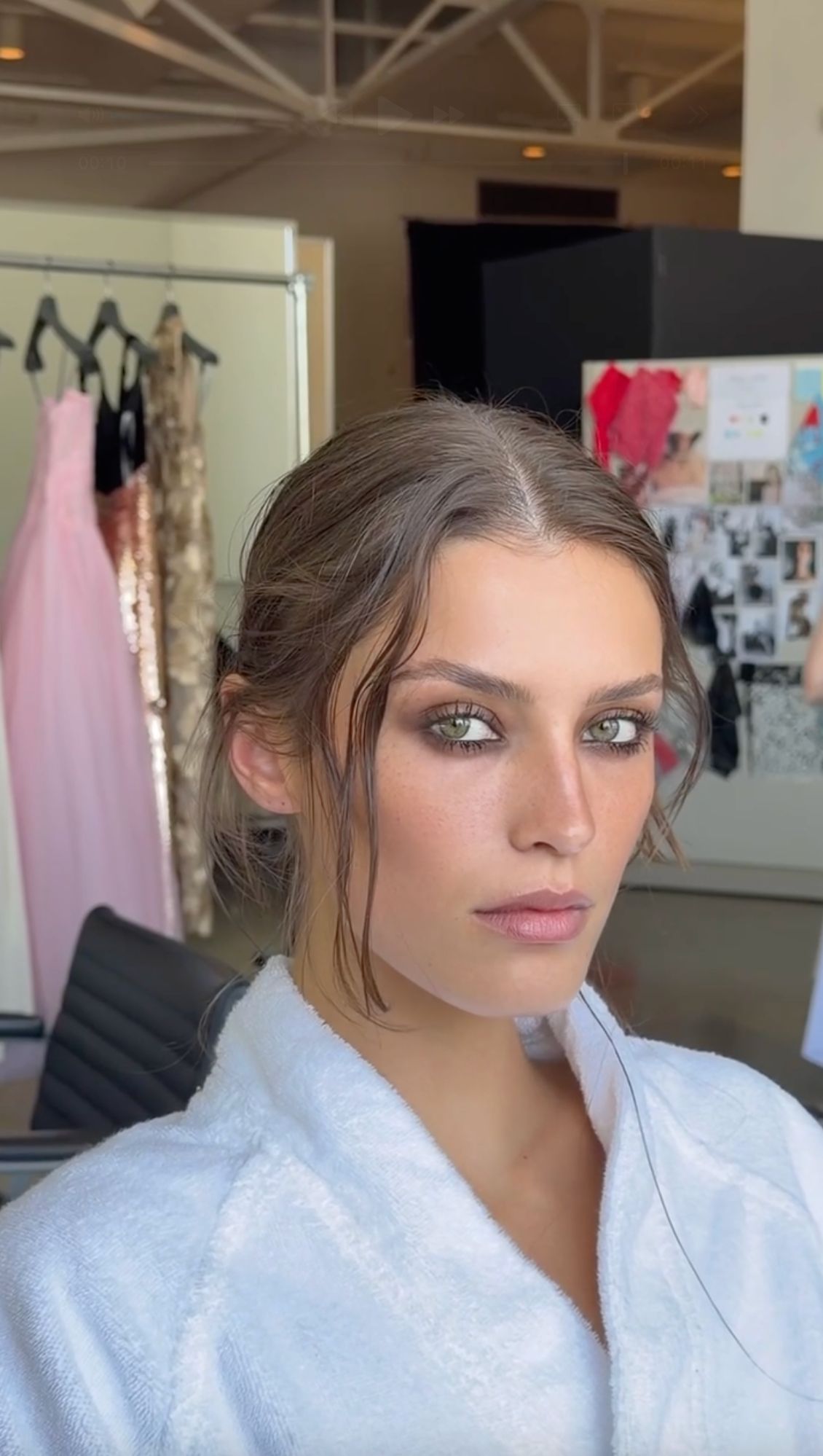 Model backstage wearing a soft, smudged brown smokey eye with defined lashes