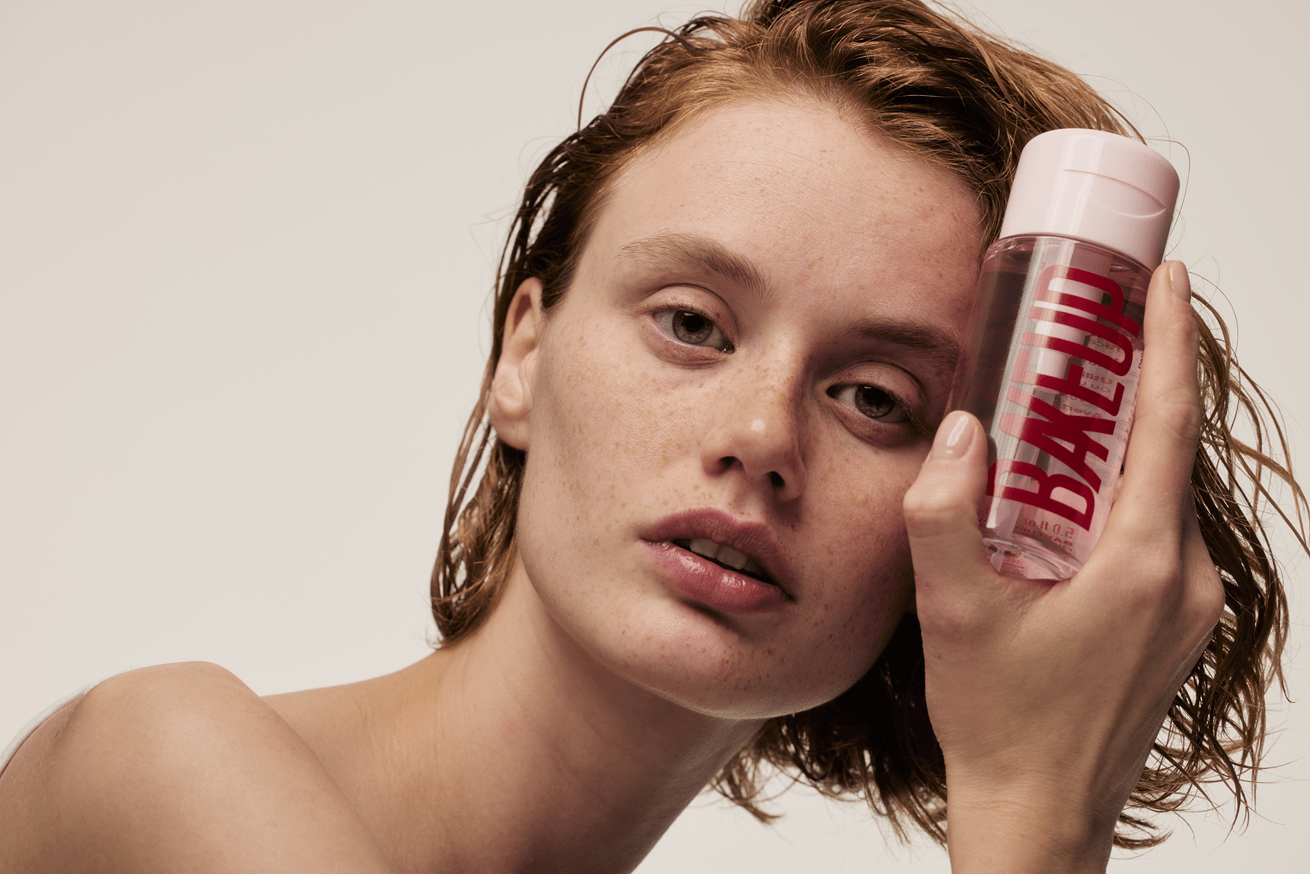 Girl holding a Micellar Water Makeup Remover from Bakeup against a plain background